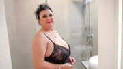 Chubby mature rubs her fat pussy under the warm shower